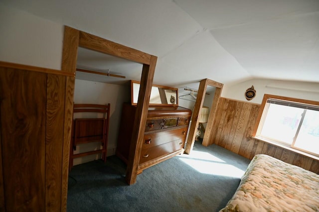 bedroom with carpet floors, wood walls, and vaulted ceiling