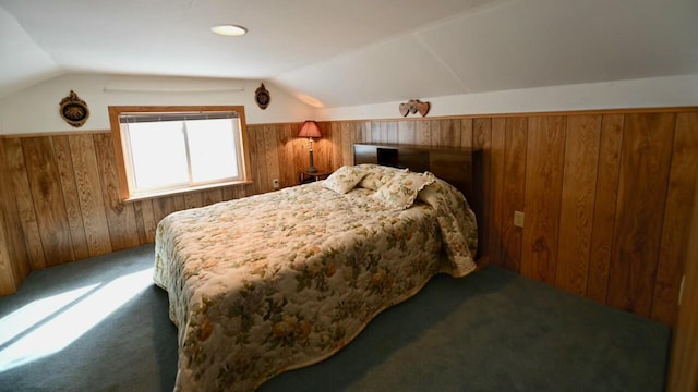 carpeted bedroom featuring wooden walls and vaulted ceiling