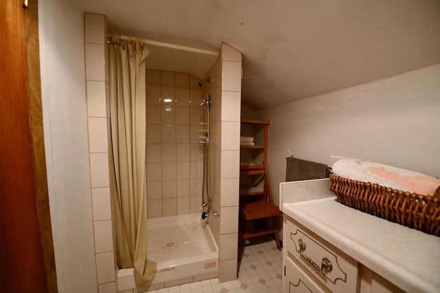 bathroom with tile patterned floors, a stall shower, and vaulted ceiling