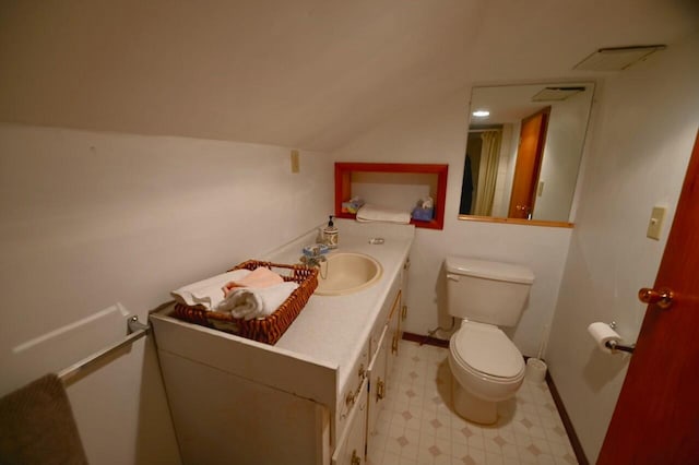 half bathroom with visible vents, toilet, vaulted ceiling, tile patterned floors, and vanity