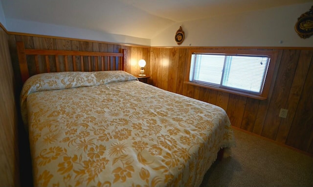 bedroom with vaulted ceiling, carpet flooring, and wood walls