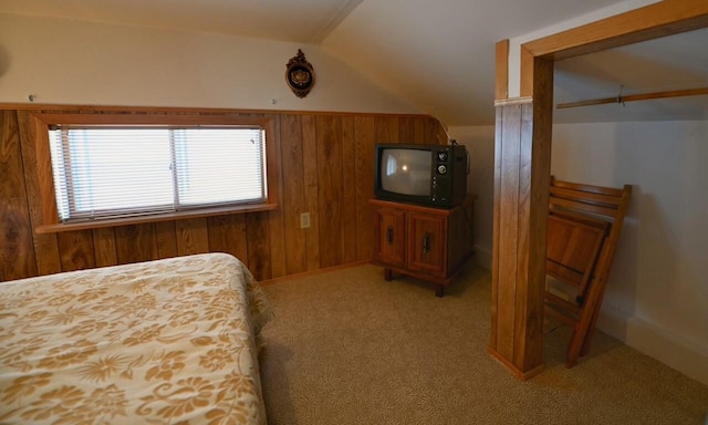 bedroom featuring light carpet, wood walls, and vaulted ceiling