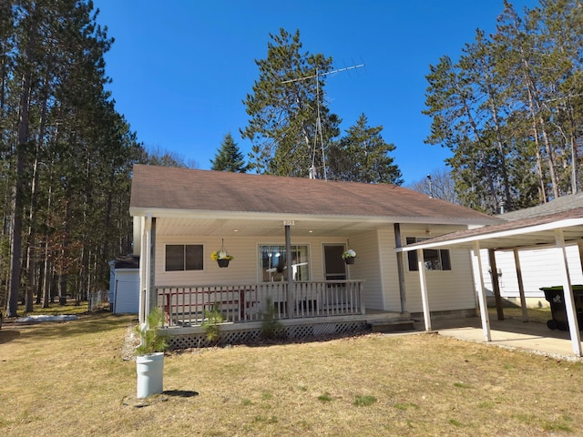 view of front of property with a shingled roof, a porch, and a front lawn