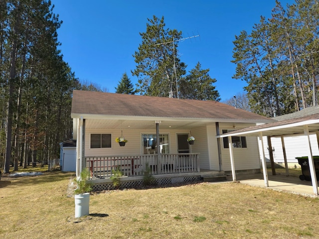 view of front of house featuring roof with shingles, a front yard, and a porch