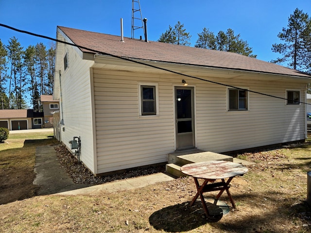 back of property with roof with shingles