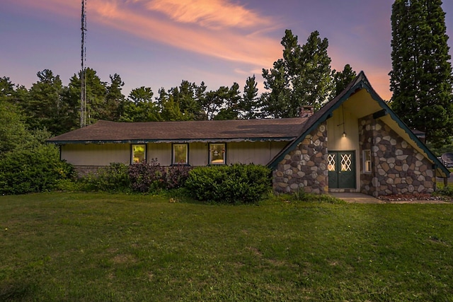 view of front facade featuring a yard and stone siding