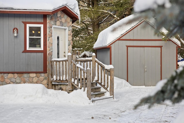 snow covered structure featuring an outdoor structure