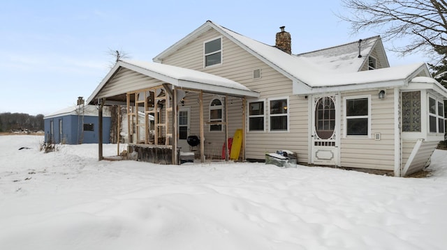 snow covered property with a chimney