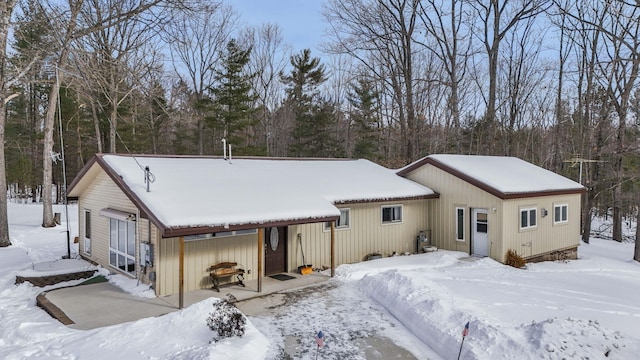 snow covered back of property with a garage