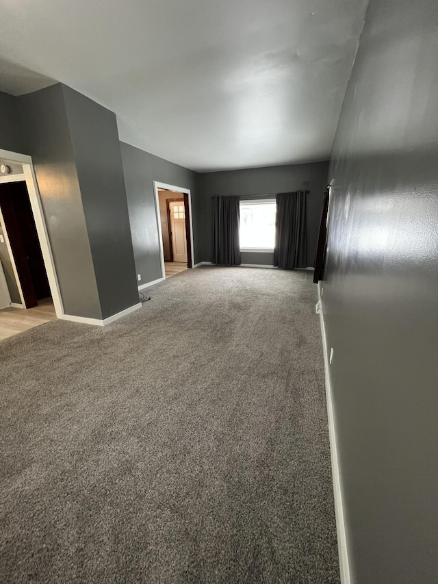 empty room featuring light colored carpet and baseboards