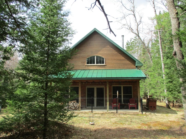 back of property featuring a patio and metal roof