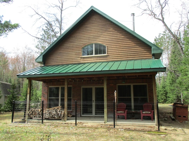 rear view of property with french doors, a patio area, a standing seam roof, and metal roof