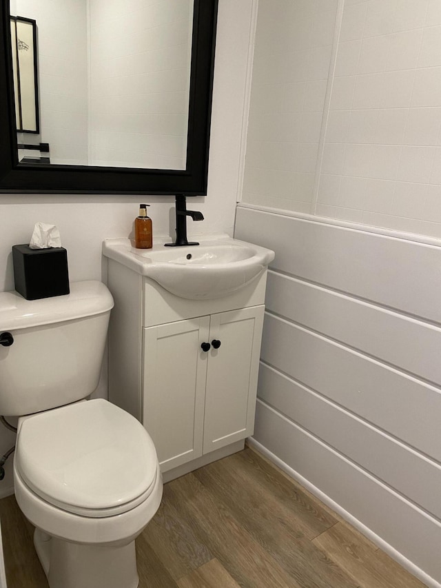 bathroom with toilet, wood finished floors, and vanity