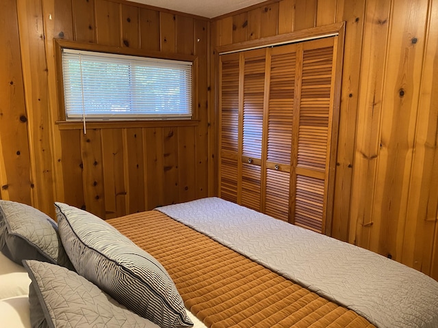 bedroom featuring a closet and wooden walls