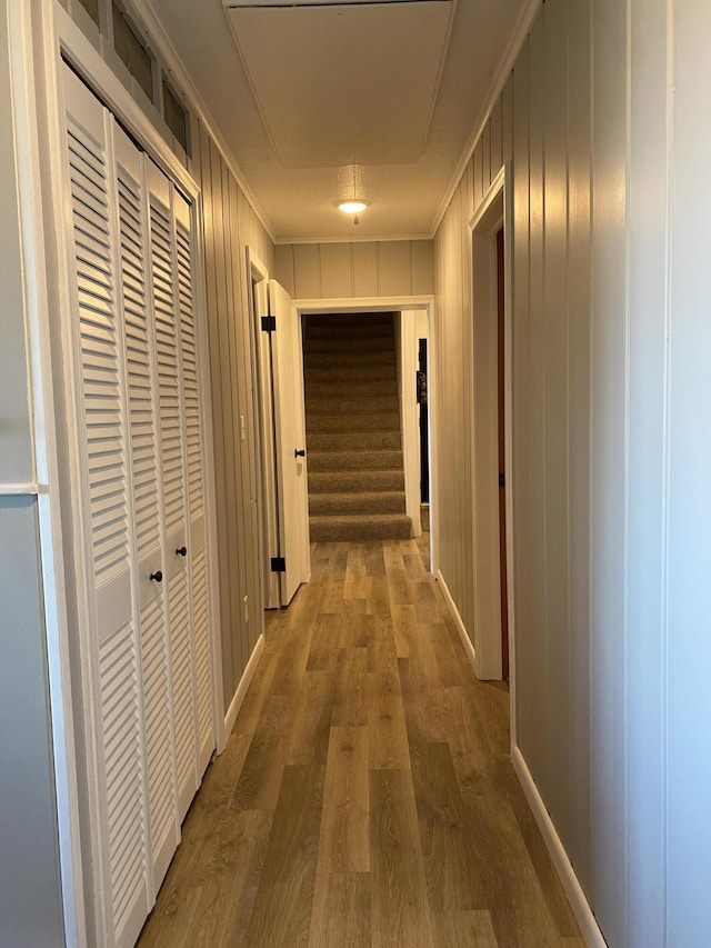 hall with ornamental molding, stairs, and wood finished floors