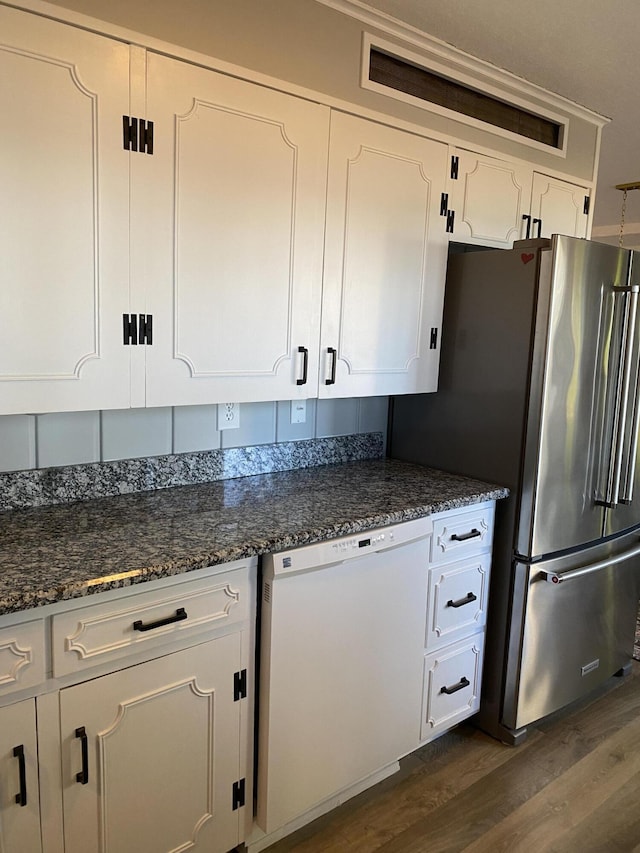 kitchen featuring dark stone counters, dark wood-type flooring, white cabinets, dishwasher, and high quality fridge