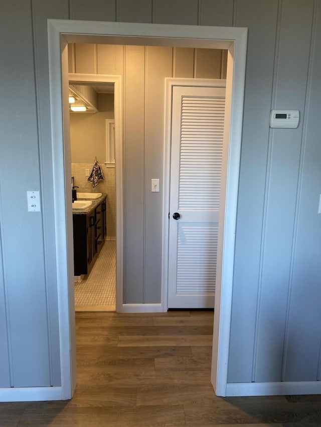 hall featuring a decorative wall and wood finished floors