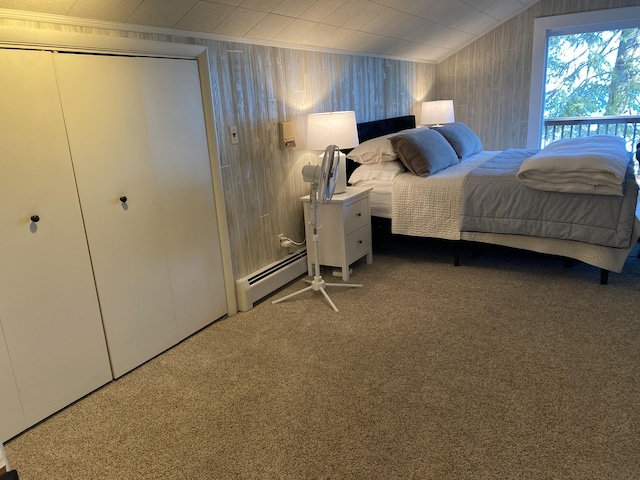 carpeted bedroom featuring a closet, baseboard heating, wood walls, and lofted ceiling