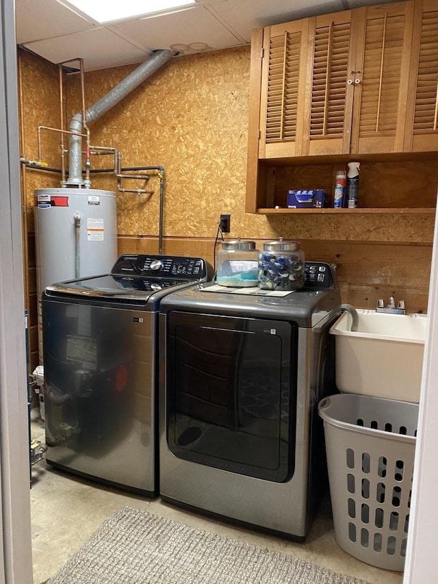 laundry area with a sink, cabinet space, water heater, and washing machine and clothes dryer