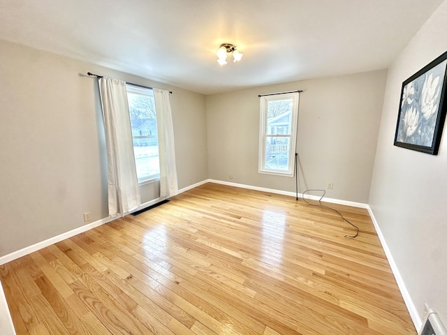 unfurnished room featuring baseboards and light wood finished floors