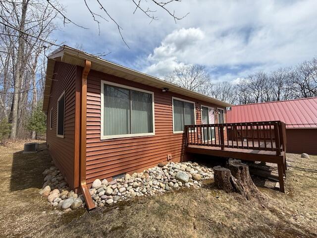 rear view of house featuring central AC unit and a wooden deck