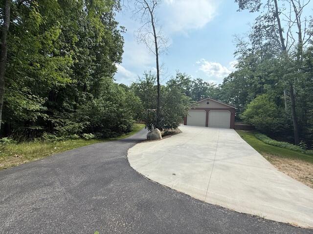 100 Innsbruck Ave, Roscommon, MI 48653 - view of front of home featuring an outbuilding, a garage, and concrete driveway