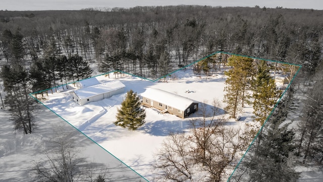 snowy aerial view featuring a forest view