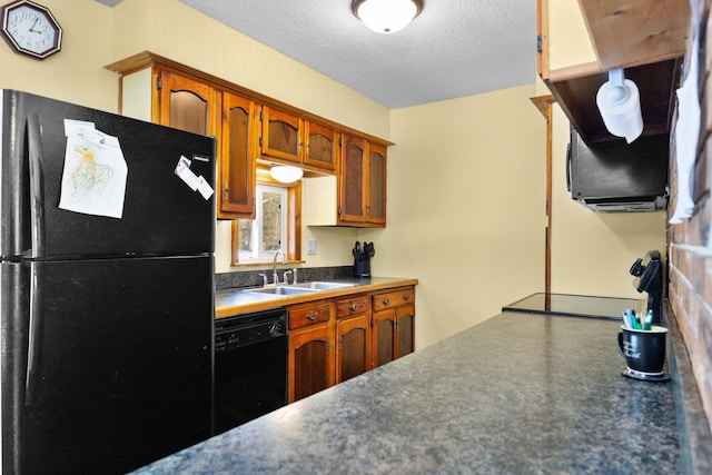 kitchen with dark countertops, black appliances, brown cabinetry, a textured ceiling, and a sink