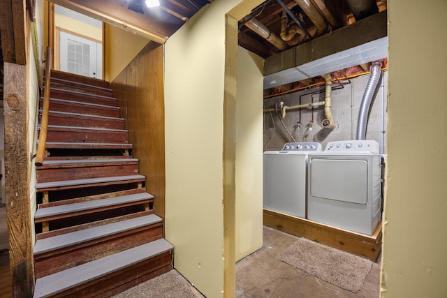 staircase featuring washer and clothes dryer and unfinished concrete floors