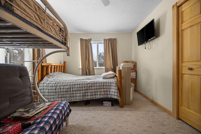 bedroom with baseboards, carpet floors, a textured ceiling, and ceiling fan