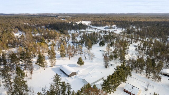 snowy aerial view with a wooded view