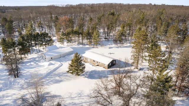 snowy aerial view featuring a forest view