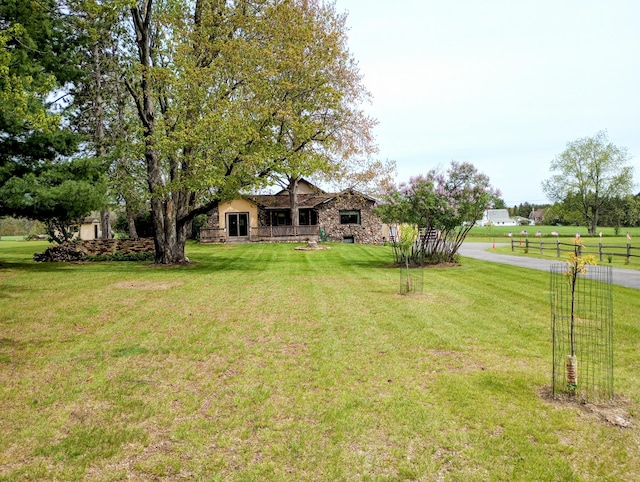 8110 Perry Rd, Houghton Lake, MI 48629 - view of front facade with a front lawn and stone siding