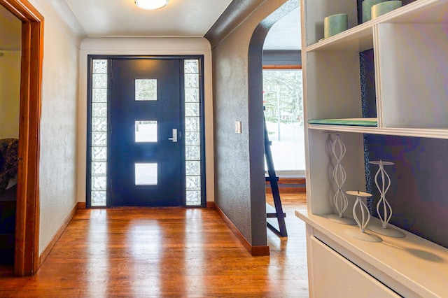 208 Stuckey Ave, Roscommon, MI 48653 - entrance foyer featuring a textured wall, arched walkways, and wood finished floors