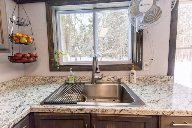 208 Stuckey Ave, Roscommon, MI 48653 - room details featuring light countertops, a sink, a textured wall, and dark brown cabinets