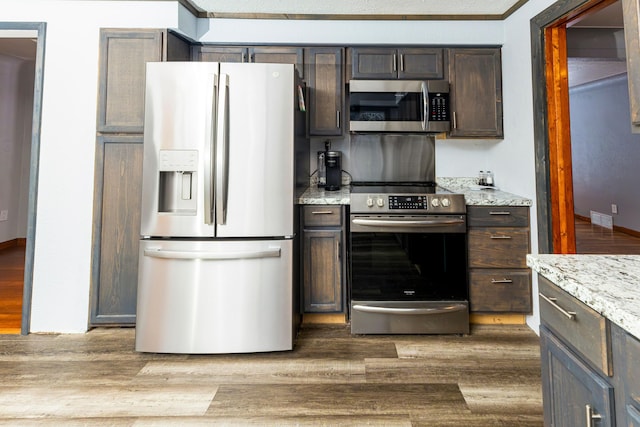 208 Stuckey Ave, Roscommon, MI 48653 - kitchen with dark brown cabinetry, wood finished floors, and stainless steel appliances