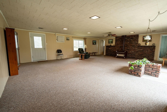 3222 E Houghton Lake Dr, Houghton Lake, MI 48629 - below grade area with a wood stove, carpet flooring, crown molding, and a ceiling fan