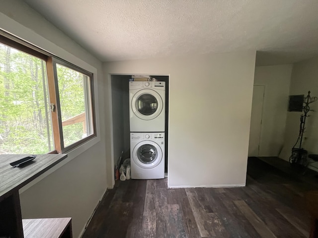 8598 N Sherman Rd, Frederic, MI 49733 - laundry area with stacked washer / drying machine, a textured ceiling, dark wood-style flooring, and baseboards