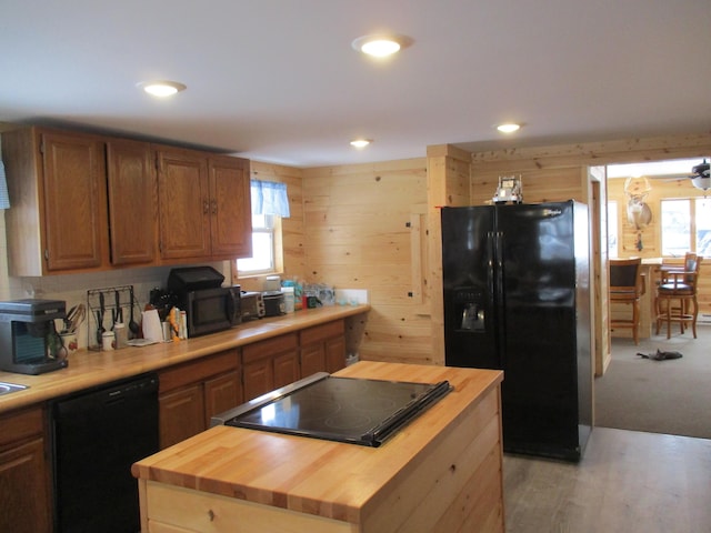 6876 Old Alba Rd, Gaylord, MI 49735 - kitchen with a kitchen island, black appliances, wooden walls, wood counters, and recessed lighting