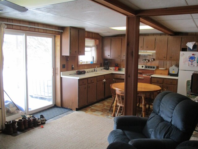 6876 Old Alba Rd, Gaylord, MI 49735 - kitchen featuring range, brown cabinets, light countertops, open floor plan, and under cabinet range hood