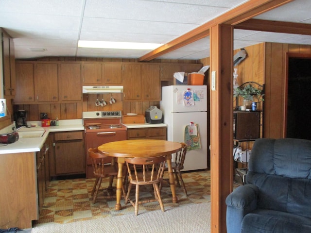 6876 Old Alba Rd, Gaylord, MI 49735 - kitchen featuring freestanding refrigerator, range, under cabinet range hood, and brown cabinetry