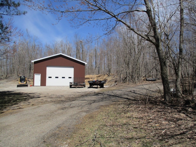 6876 Old Alba Rd, Gaylord, MI 49735 - view of side of property featuring a garage, an outdoor structure, and dirt driveway