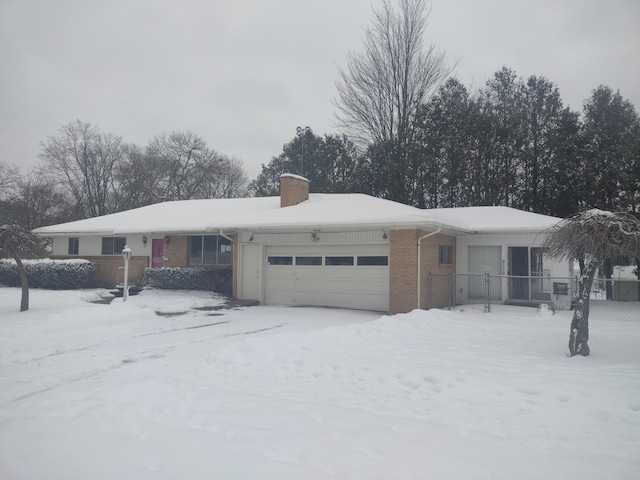 ranch-style house with brick siding, an attached garage, and a chimney