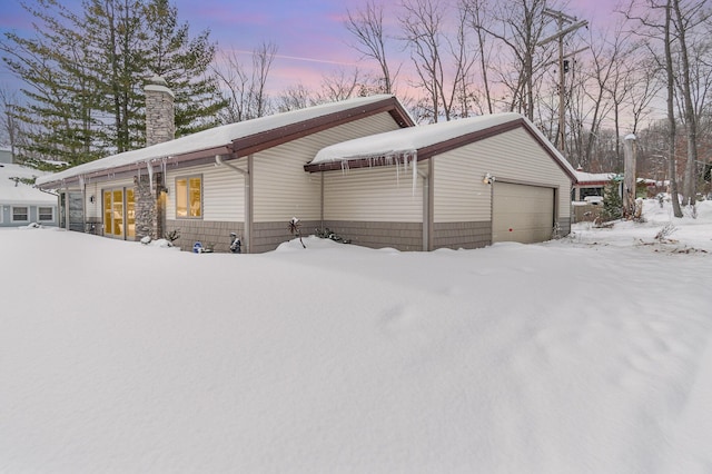 view of snowy exterior featuring a chimney