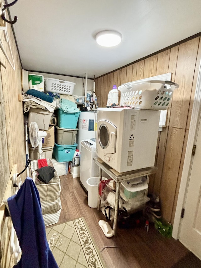 washroom featuring wooden walls, wood finished floors, laundry area, and water heater