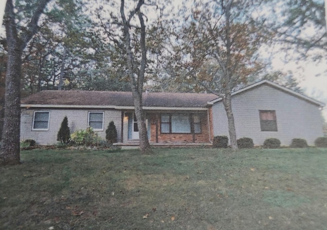 ranch-style house featuring a front yard and brick siding