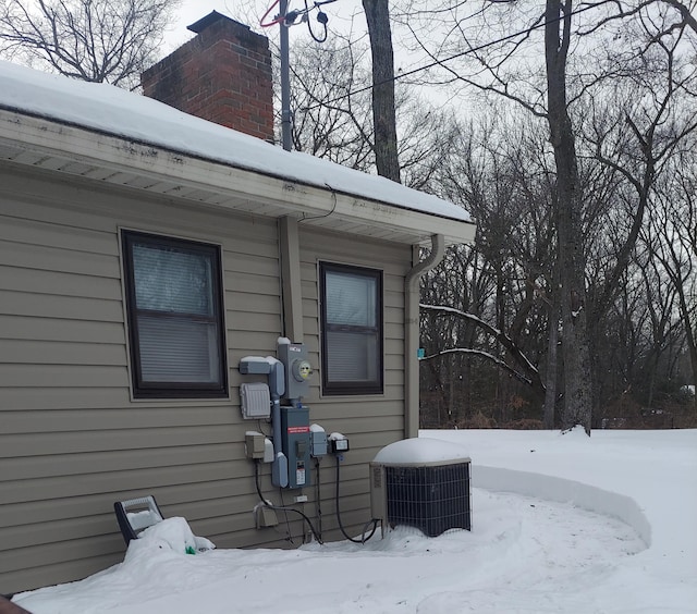 exterior space featuring central AC and a chimney