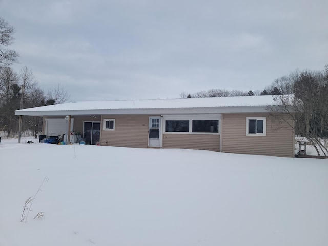 snow covered property featuring a garage