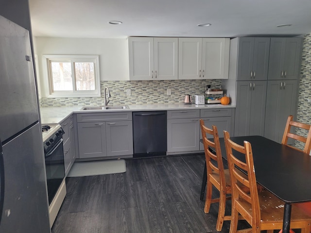 kitchen featuring dark wood-type flooring, gray cabinets, a sink, backsplash, and stainless steel appliances