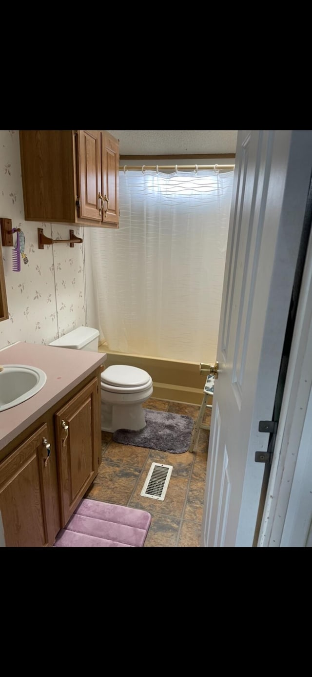 bathroom with visible vents, toilet, wallpapered walls, shower / bath combination with curtain, and vanity